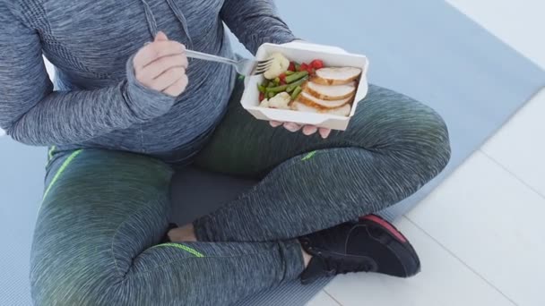 Fitness e comida saudável. Mulher está descansando e comer uma comida saudável depois de um treino em um branco em — Vídeo de Stock