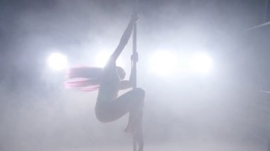 Dans ve akrobasi kavramı. Seksi kadın kutup ışıkları ve duman ile karanlık iç dans