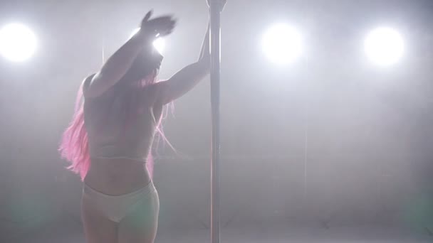 Concetto di danza e acrobazia. Sexy pole dance donna in interni scuri con luci e fumo — Video Stock