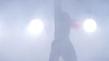 Dans ve akrobasi kavramı. Seksi kadın kutup ışıkları ve duman ile karanlık iç dans