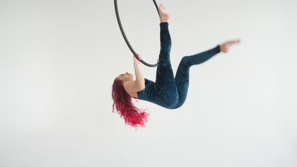 Concept de danse et d'acrobatie. Jeune femme dans le cerceau aérien sur un fond blanc — Video