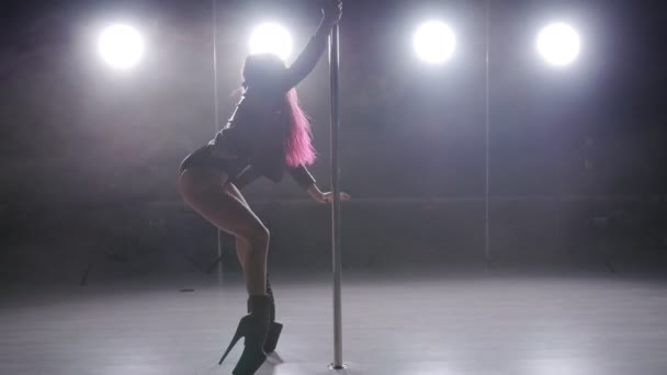ダンスとアクロバットのコンセプトです。ライトと煙で暗い室内でセクシーな女性のポールダンス — ストック動画