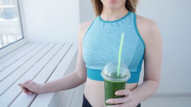 Sport et mode de vie sain concept - jeune femme boire smoothie vert — Video