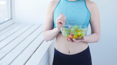 Sağlıklı beslenme kavramı. Genç kadın sağlıklı salata egzersiz sonrası yemek