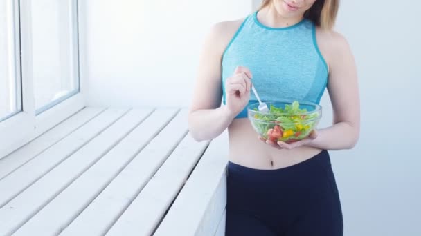 Un concetto di alimentazione sana. Giovane donna in forma mangiare insalata sana dopo l'allenamento — Video Stock