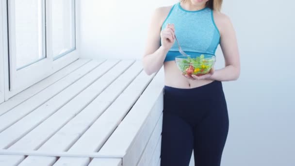 健康饮食理念。年轻的适合妇女在锻炼后吃健康的沙拉 — 图库视频影像