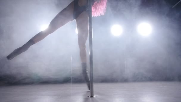 Молода жінка з рожевим волоссям полюс танцює в темному інтер'єрі з підсвічуванням і димом — стокове відео