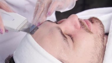 Ultrasonik yüz yüzey. Şevval Özçelik Güzellik bir genç adamın yüzünü temizler