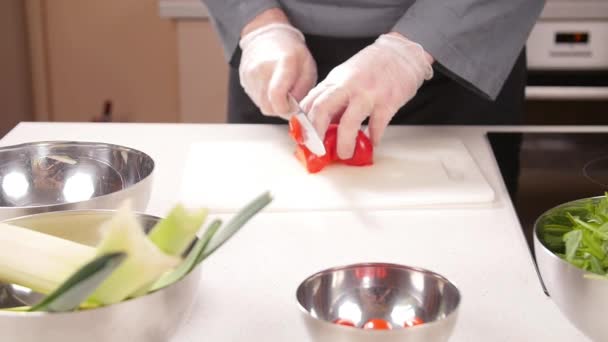 Koken concept. Jonge man snijdt de groenten in de keuken — Stockvideo