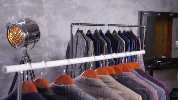 Young man with beard choosing suit in a shop — Stock Video