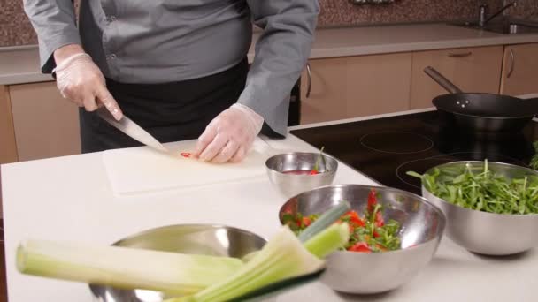 Concepto de cocina. Joven corta verduras en la cocina — Vídeos de Stock