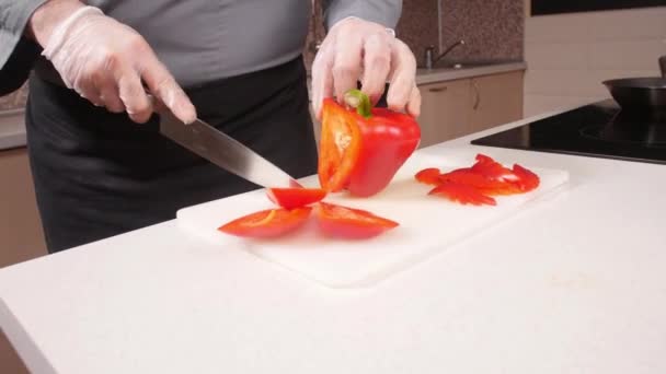 Концепція приготування їжі. Молодий чоловік нарізає овочі на кухні — стокове відео