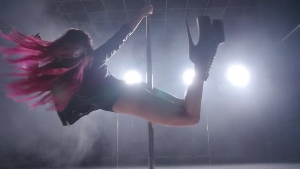 Концепция танца и акробатики. Молодая стройная женщина танцует в темном интерьере с подсветкой и дымом — стоковое видео