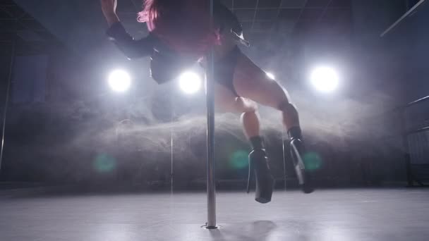 Концепция танца и акробатики. Молодая стройная женщина танцует в темном интерьере с подсветкой и дымом — стоковое видео