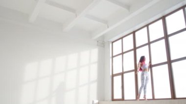 Germe ve esneklik kavramını. Genç kadın beyaz bir iç penceresinde yakınındaki germe yapmak spor giyim