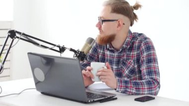 Podcasting, akış ve radyo yayın kavramı. Stüdyo ya da evde bir mikrofon ile bilgisayar, genç adam