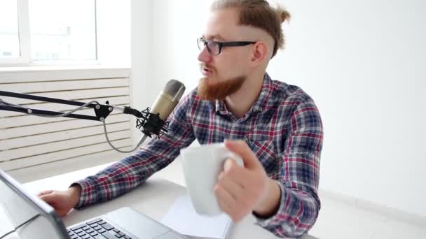 Podcasting, streaming e radiodiffusione concetto. Giovanotto al computer con un microfono in studio o a casa — Video Stock