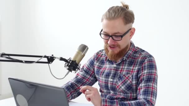 Podcasting, συνεχούς ροής και την έννοια της ραδιοφωνίας ραδιόφωνο. Νεαρός άνδρας στον υπολογιστή με ένα μικρόφωνο στο studio ή στο σπίτι — Αρχείο Βίντεο