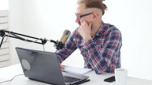 Podcasting, streaming e conceito de radiodifusão. Jovem no computador com um microfone no estúdio ou em casa — Vídeo de Stock