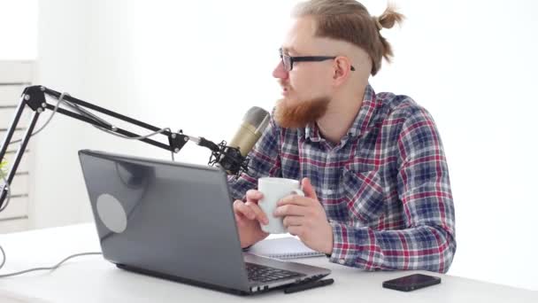 Podcasting, streaming a rozhlasové vysílání konceptu. Mladý muž na počítači s mikrofonem v ateliéru nebo u vás doma — Stock video