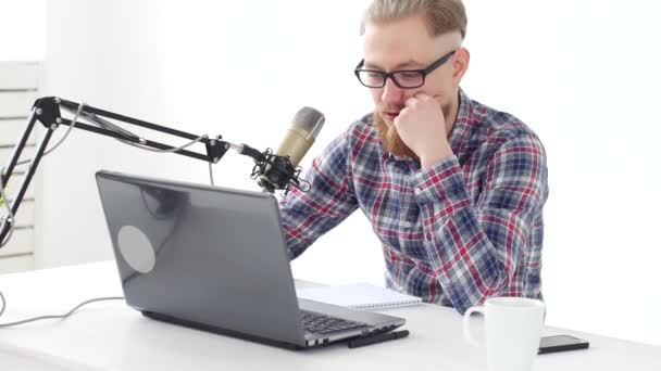 Podcasting, streaming och radio sänder koncept. Ung man på datorn med en mikrofon i studion eller hemma — Stockvideo