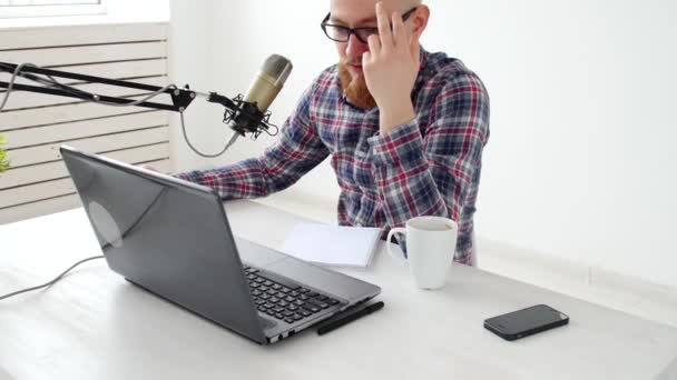 Podcasting, streaming en begrip voor radio-omroep. Jonge man achter de computer met een microfoon in de studio of thuis — Stockvideo