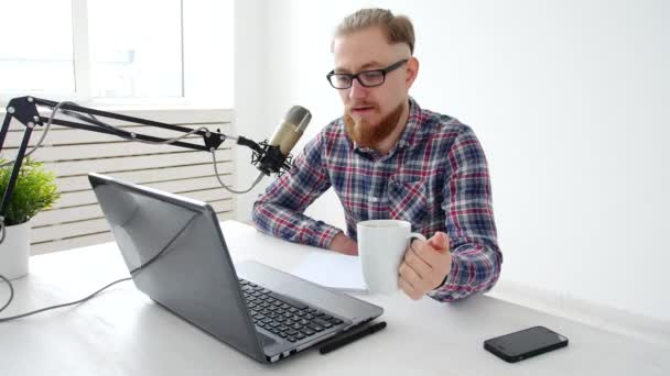 Podcasting, streaming és a rádió műsorszolgáltató fogalmát. Fiatal férfi-egy mikrofonnal, stúdióban vagy otthon a számítógépnél — Stock videók