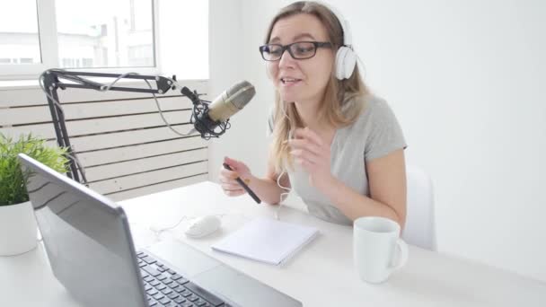 Concept de streaming et de diffusion. Jeune fille gaie dans le studio parle dans un microphone — Video