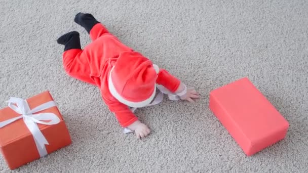 Concept de Noël. Bébé mignon en costume du Père Noël, à la recherche d'un cadeau — Video