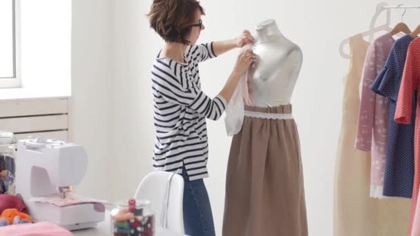 Concepto de pequeña empresa y pequeña producción. Joven bonita modista mujer cose ropa en el taller — Vídeo de stock