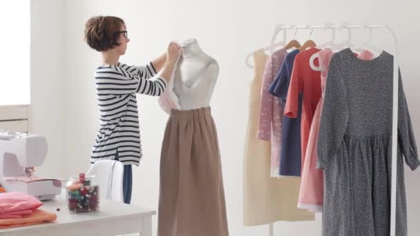 Concepto de pequeña empresa y pequeña producción. Joven bonita modista mujer cose ropa en el taller — Vídeo de stock