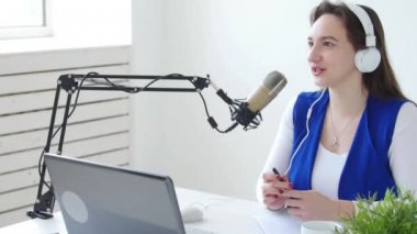 Akarsu ve yayın kavramını. Neşeli kız stüdyoda bir mikrofona konuşur