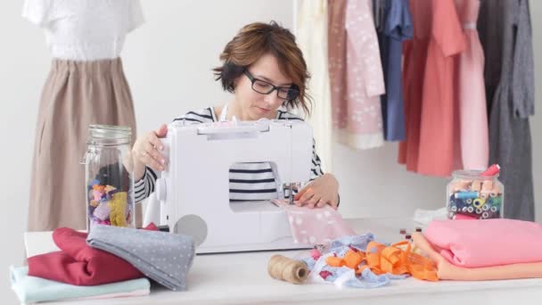 Kleinunternehmen und Hobby-Konzept. Modedesignerin arbeitet im hellen Atelier an ihren Entwürfen — Stockvideo