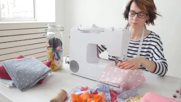Kleinunternehmen und Hobby-Konzept. Modedesignerin arbeitet im hellen Atelier an ihren Entwürfen — Stockvideo