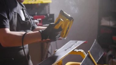 Kayak bakım ve onarım konsepti. Ağda yapan atölye çalışanı kayak ve snowboard tamiri yapıyor