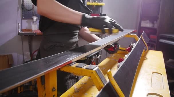 Concepto de mantenimiento y reparación de esquí. Trabajador de taller haciendo depilación y reparaciones esquí y snowboard — Vídeos de Stock