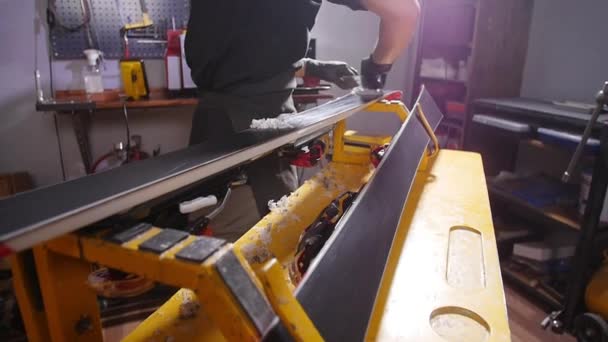 Concepto de mantenimiento y reparación de esquí. Trabajador de taller haciendo depilación y reparaciones esquí y snowboard — Vídeos de Stock