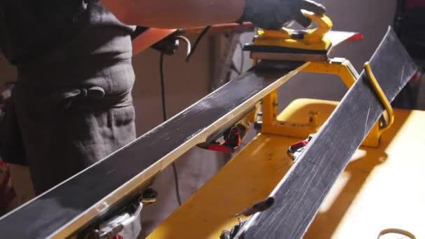 Koncepce údržby a oprav lyží. Dílenská pracovnice, která provádí voskování a opravy lyžařského a snowboardu — Stock video