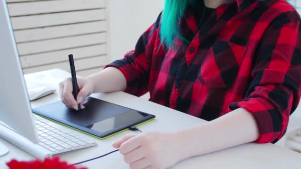 Concepto de trabajo autónomo o de oficina. Joven diseñadora gráfica femenina con cabello coloreado trabajando en la oficina o en casa — Vídeo de stock