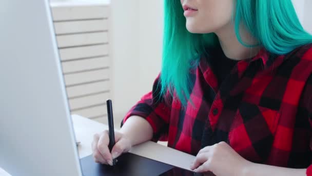 Concepto de trabajo autónomo o de oficina. Joven diseñadora gráfica femenina con cabello coloreado trabajando en la oficina o en casa — Vídeos de Stock