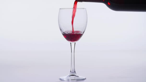 Concepto de comida y bebida. Vino tinto o rosado vertido en una copa sobre un fondo blanco . — Vídeos de Stock