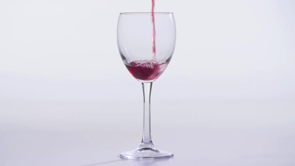 Concetto di cibo e bevande. Vino rosso o rosa versato in un bicchiere su fondo bianco . — Video Stock