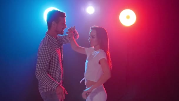 Concept of dance and relationships. Young beautiful couple dancing sensual dance in color light — Stock Video