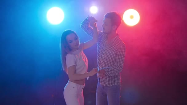 ダンスと人間関係の概念。若い美しいカップルは、色の光で官能的なダンスを踊ります — ストック動画
