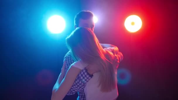 Concept of dance and relationships. Young beautiful couple dancing sensual dance in color light — Stock Video