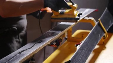 Kayak veya snowboard atoksve reapair kavramı. Temel onarım ve servis yapan kış dükkanı işçisi
