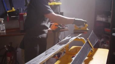 Kayak veya snowboard atoksve reapair kavramı. Temel onarım ve servis yapan kış dükkanı işçisi
