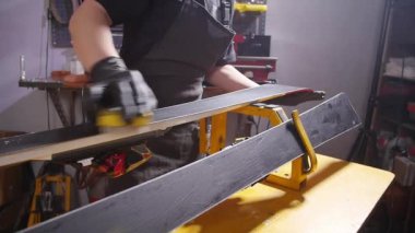 Kayak veya snowboard atoksve reapair kavramı. Temel onarım ve servis yapan kış dükkanı işçisi