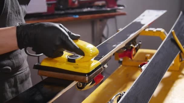 Налаштування лиж або сноуборду та концепція репаїру. Працівник зимового магазину робить базовий ремонт та обслуговування — стокове відео