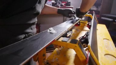 Kayak veya snowboard atoksve reapair kavramı. Temel onarım ve servis yapan kış dükkanı işçisi